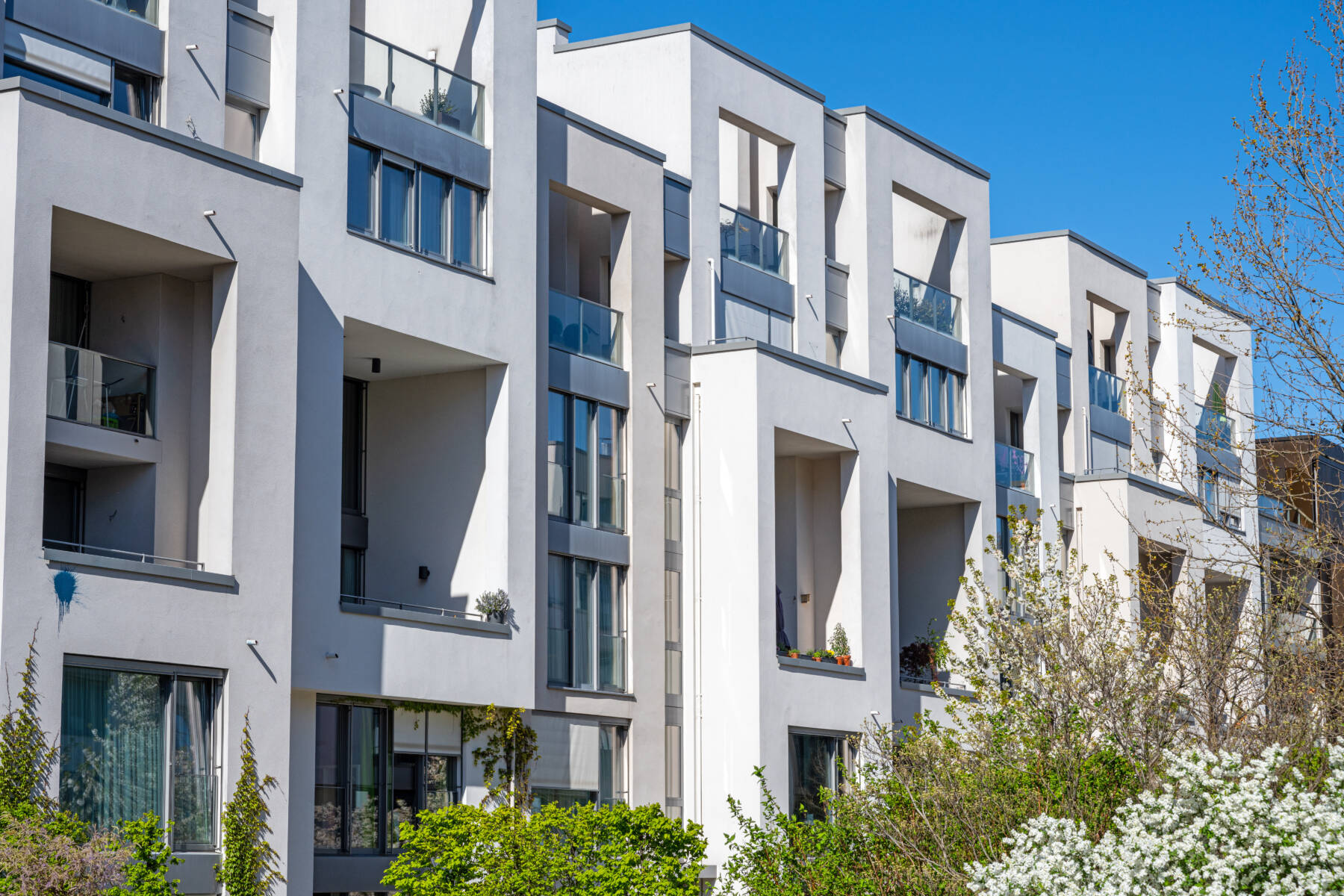 Reihe moderner weißer Stadthäuser mit Balkonen in Berlin, Deutschland.